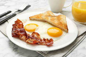 Delicious breakfast with sunny side up eggs served on white marble table, closeup