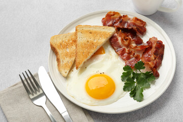 Delicious breakfast with sunny side up egg served on light table, closeup