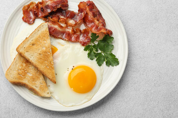 Delicious breakfast with sunny side up egg on light table, top view