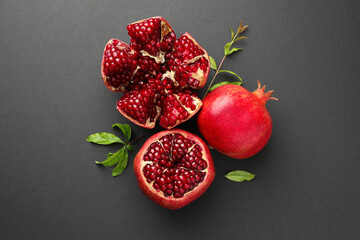 Fresh ripe pomegranates and leaves on grey background, top view