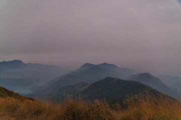 Obraz premium The sky is cloudy and the mountains are covered in fog