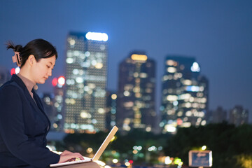 Businesswoman Working Late Outdoors in Cityscape