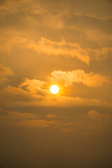 Obraz premium The sun is setting and the sky is filled with clouds