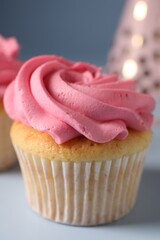 Delicious cupcake with bright cream on light background, closeup