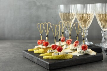 Tasty canapes with pears, blue cheese and prosciutto on grey table, closeup. Space for text