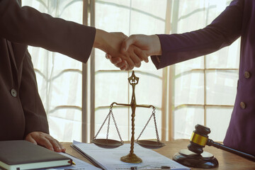 Shaking hands, A group of lawyers and clients engage in a professional meeting at a law office,...