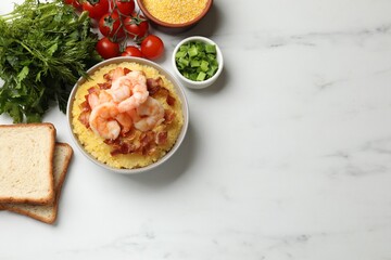 Fresh tasty shrimps, bacon and grits in bowl on white marble table, flat lay. Space for text