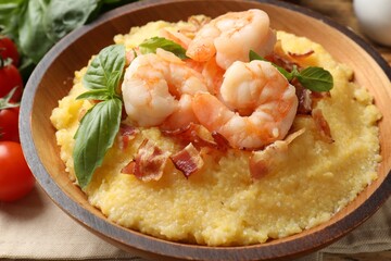 Fresh tasty shrimps, bacon, grits and basil in bowl on table, closeup