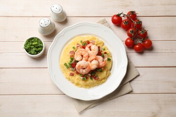 Plate with fresh tasty shrimps, bacon, grits, green onion and pepper on wooden table, top view