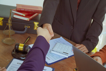 Shakinghands  A group of lawyers and clients engage in a professional meeting at a law office,...