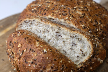 Round freshly oat baked bread sliced on a cutting board.