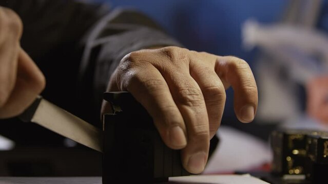 Man cutting open a black box with a knife