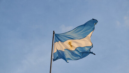 Details of an Argentine flag on a blue sky.