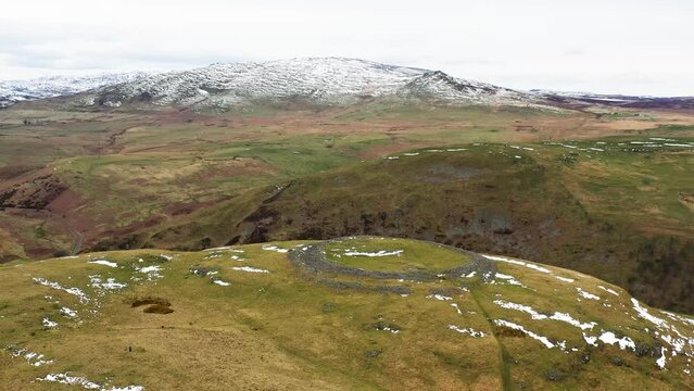 Brough Law prehistoric Iron Age hillfort. N.W. over River Breamish valley near Ingram, Cheviot Hills, Northumberland, England. Video fly in from S.E.