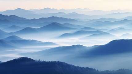 Misty mountain range at dawn, layered in hues of blue and gray for a peaceful setting