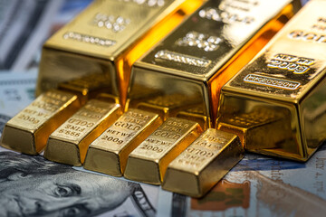 Finance concept gold bullion lie on 100 US Dollar bills background