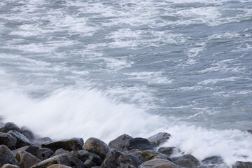 Obraz premium Ocean waves crashing on a rocky shore