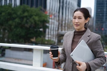 Confident Businesswoman with Coffee and Tablet Outdoors