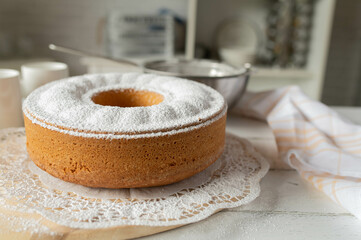 Uncut and whole bundt cake just finished with powdered sugar topping in the kitchen