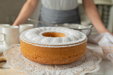 Fresh and whole bundt cake with powdered sugar topping in the kitchen
