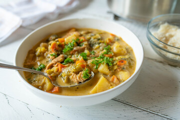 Potato soup with leek and turkey meat on a plate