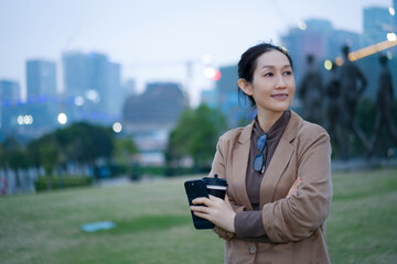 Confident Businesswoman with Coffee in Urban Park