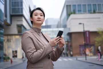 Confident Businesswoman Texting on Smartphone in Urban Setting