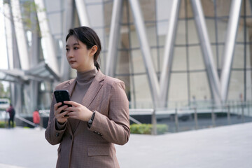Professional Woman Using Smartphone Outside Modern Building