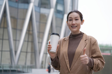 Confident Businesswoman With Coffee Giving Thumbs Up