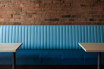 Blue Banquet and tables in restaurant and red brick wall