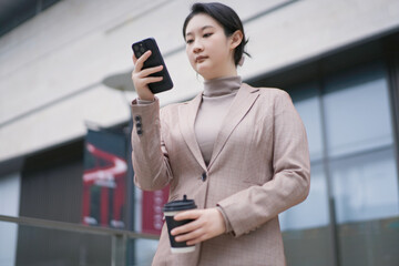 Professional Woman Checking Phone During Coffee Break