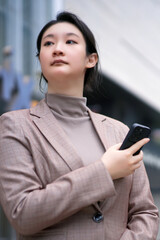 Confident Businesswoman with Smartphone in Urban Setting