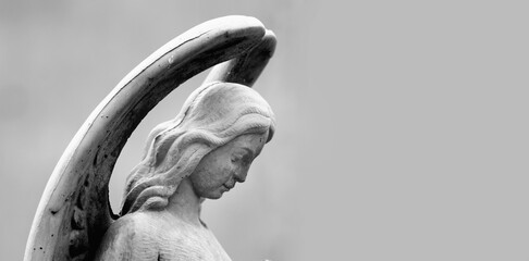 Naklejka premium Antique statue of wonderful angel. Black and white vertical image. Copy space.