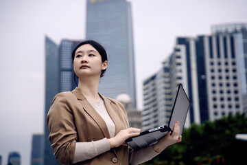 Confident Businesswoman Working on Laptop Outdoors