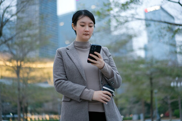 Modern Professional Woman Using Smartphone Outdoors