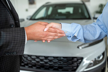 success deal at showroom - salesman and client are shaking hands