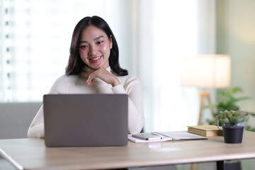 Young beautiful Asian woman working at home.