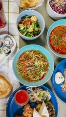 top view of delicious dishes from several cuisines on a rustic table with sushi, salad, soup, meat