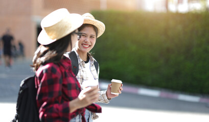 Two Asian female tourists walking on a tourist street in Bangkok, Thailand.