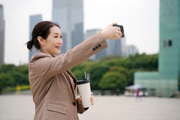 Businesswoman Enjoying Coffee Break With Selfie in the City