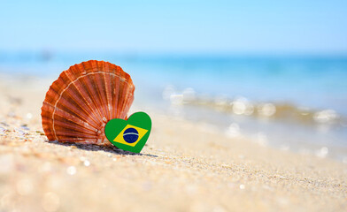 Sandy beach in Brazil. Brazil flag in the shape of a heart and a large shell. A wonderful resort
