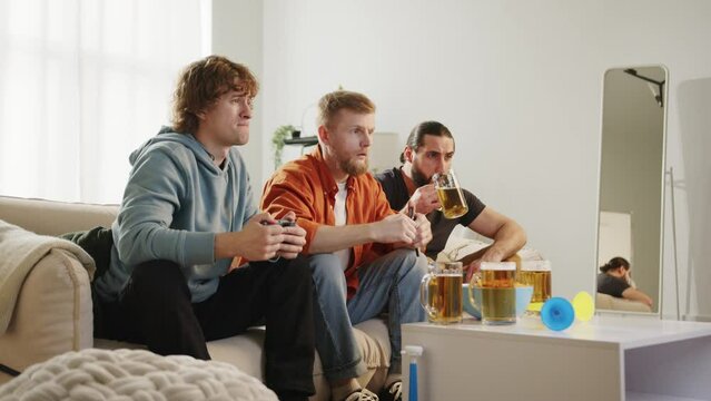 Males fan watching match on tv, drinking beer and eating chips, upset with loss result. European Germany and World football cup USA, Canada, Mexico. Football, sports and soccer fans. Slow Motion