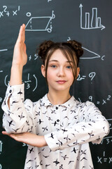 Schoolgirl raises her hand to answer teacher question.,