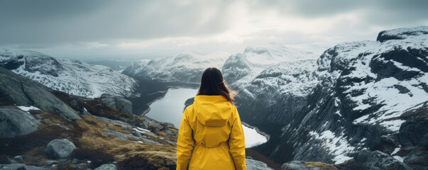 woman in rain jacket by lake in mountain landscape