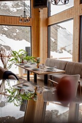 Elegant restaurant interior with snowy mountain view and warm ambiance.