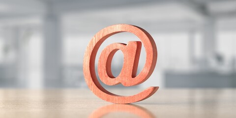 Wooden e-mail symbol on office background