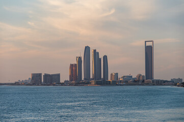 Perspective of skyscraper towers and bay cityscape skyline of Abu Dhabi, sunrise in UAE.