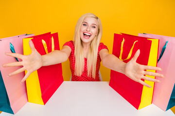 Photo portrait woman sitting at table bags opened hands embracing isolated bright orange color...