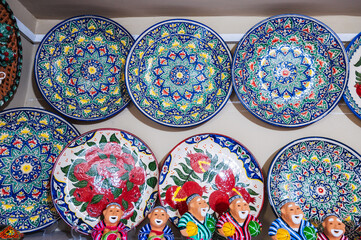 Uzbek handmade ceramic plates and figurines with hand-painted Oriental Asian patterns in souvenir store in Uzbekistan