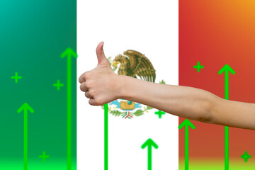 Mexico flag with green up arrows,  finger thumbs up front of Mexico flag, country statistics 